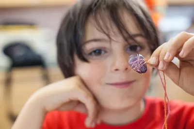 A handmade amethyst pendant held by a Mining Matters participant.