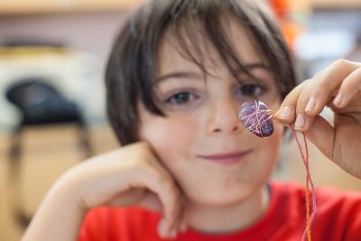 A handmade amethyst pendant held by a Mining Matters participant.