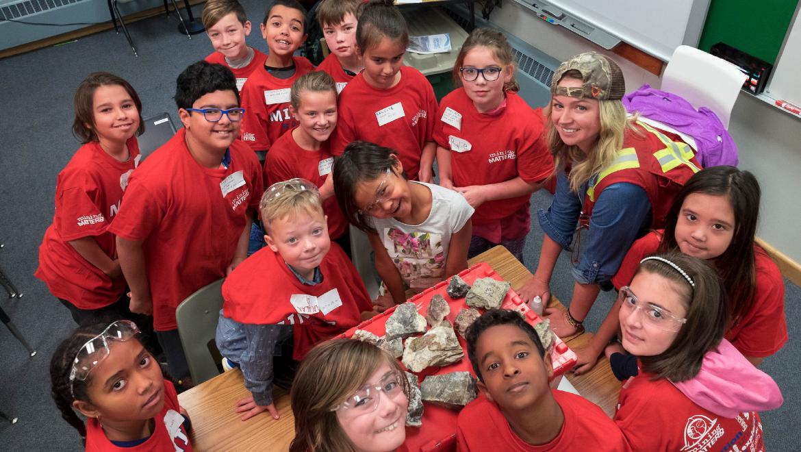 Students gathered around rock and mineral samples.