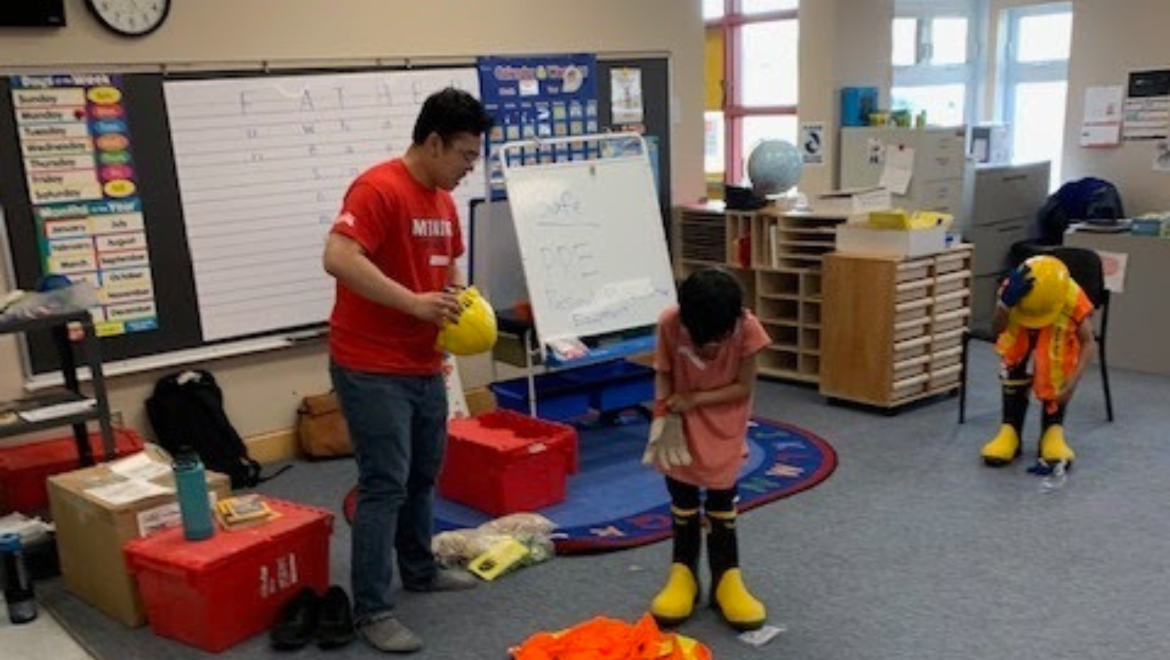 Mining Matters staff facilitating a hands-on PPE activity with students at Henry Coaster Memorial School during a previous Mining Rocks partnership program in 2023.