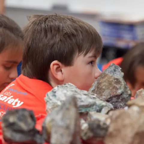 Rock samples in the foreground and Mining Matters participants in the background.