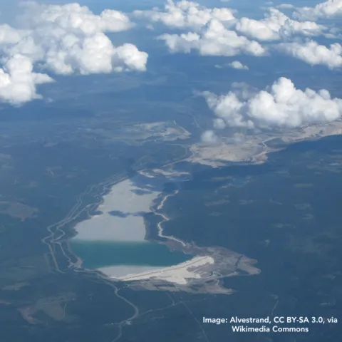 Aerial view of Highland Valley Copper Mine in British Columbia, showing the open-pit mine area, surrounding landscape, and a large tailings dam/storage facility. Image: Alvestrand, CC BY-SA 3.0, via Wikimedia Commons • Vue aérienne de la mine Highland Valley Copper en Colombie-Britannique, montrant la zone de la mine à ciel ouvert, le paysage environnant et une grande installation de stockage des résidus miniers.  Crédit image : Alvestrand, CC BY-SA 3.0, via Wikimedia Commons. 