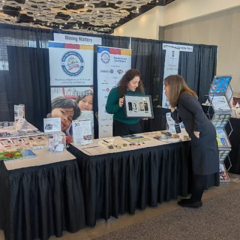 A Mining Matters staff showcasing the Critical Minerals phone display.